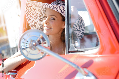 Portrait of beautiful woman in vintage red truck