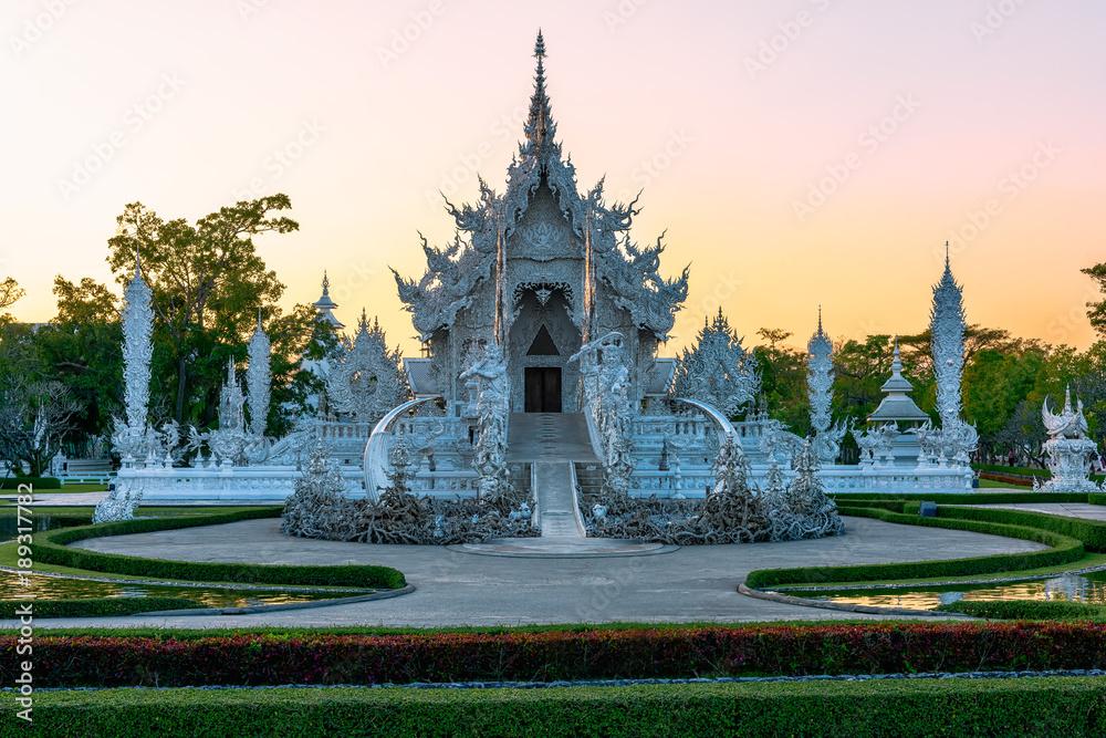 Naklejka premium Wat Rong Khun(White temple)at sunset in Chiang Rai,Thailand.23/01/2018 Wat Rong Khun is modern building, well known worldwide.It was designed by Chalermchai Kositpipat.Opened it to visitors in 1997.