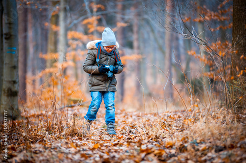 Boy with digital camera walking in the nature, hobby concept