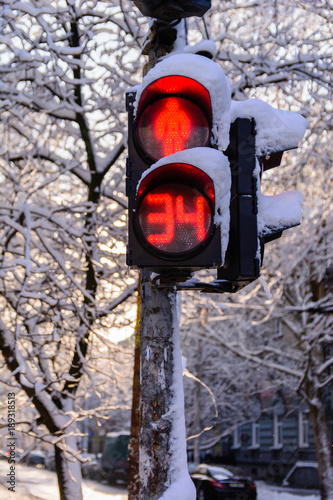 Pedestrian traffic light in a snowy winter city. prohibition or permission of passage
