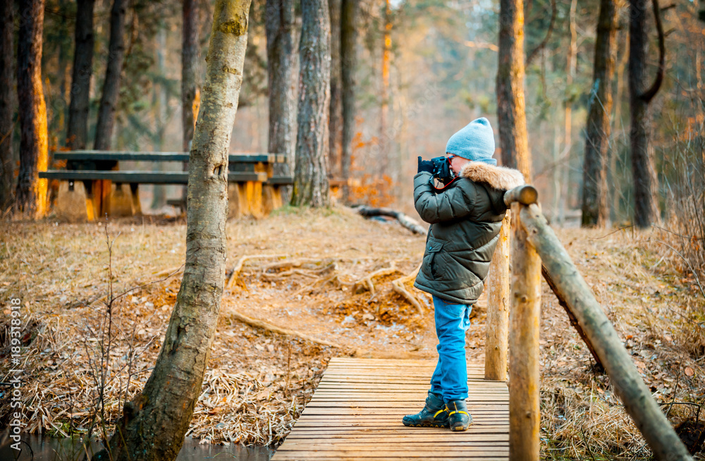 Boy using digital camera taking photo in the nature, hobby concept Boy using digital camera taking photo in the nature, hobby concept