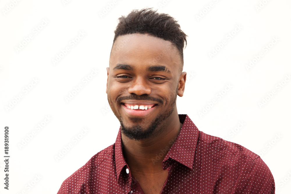 Obraz premium Close up happy young african man smiling against isolated white background
