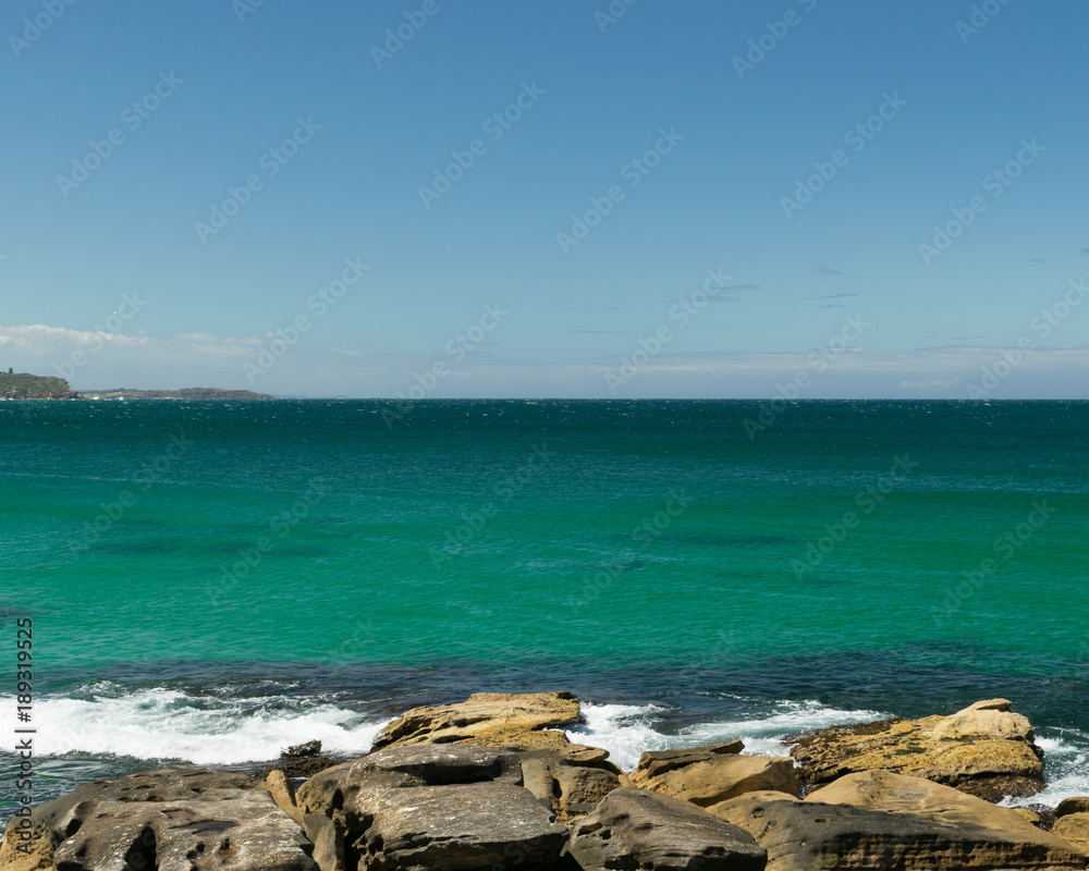 Rocks on the beach with horizon in the background - Manly Beach, Sydney, Australia