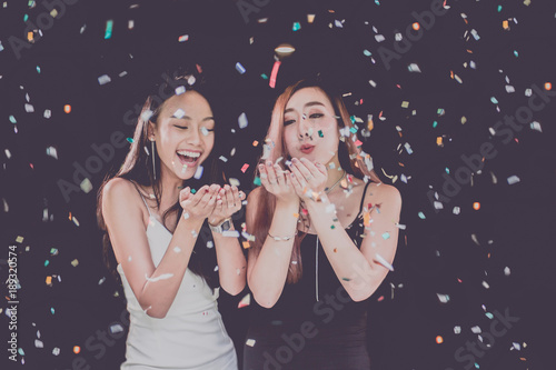 celebration party group of Two asian young  women people holding confetti happy and funny concept. In 2018 New year holiday. photo