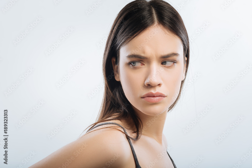 Huge problem. Serious worried attractive woman staring aside while frowning and turning her face Huge problem. Serious worried attractive woman staring aside while frowning and turning her face