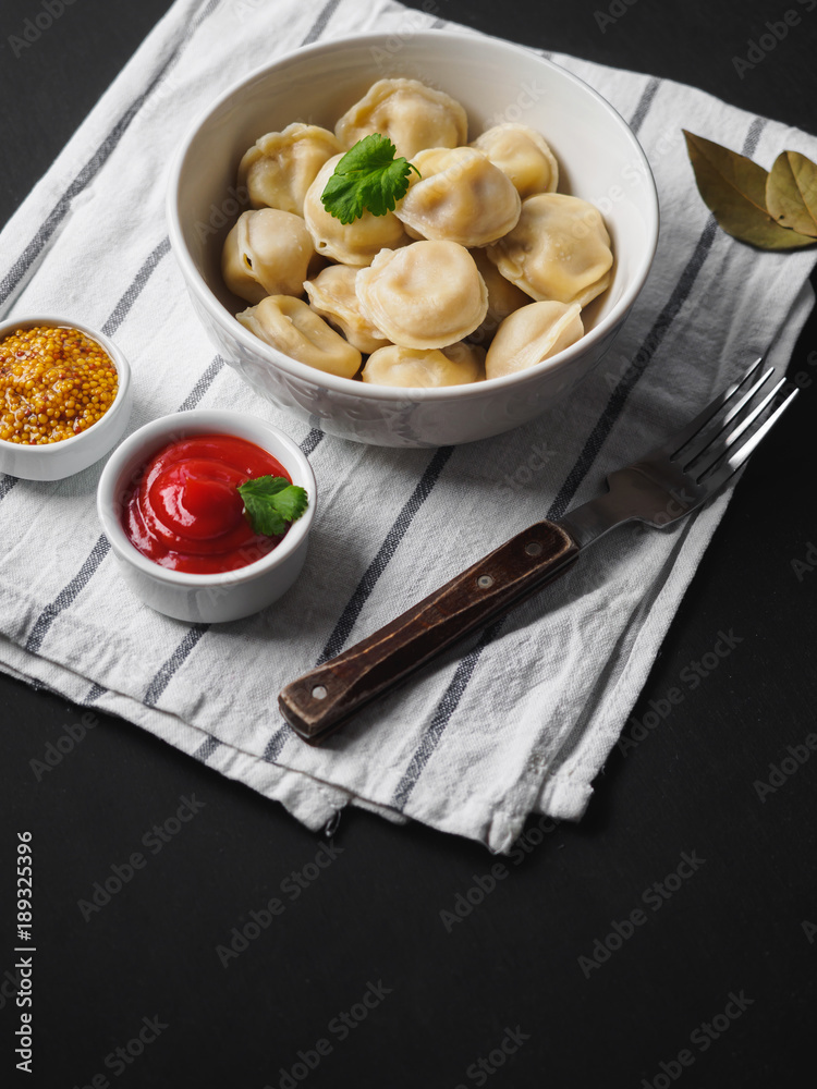 Dumplings on plate at wooden desk on black background