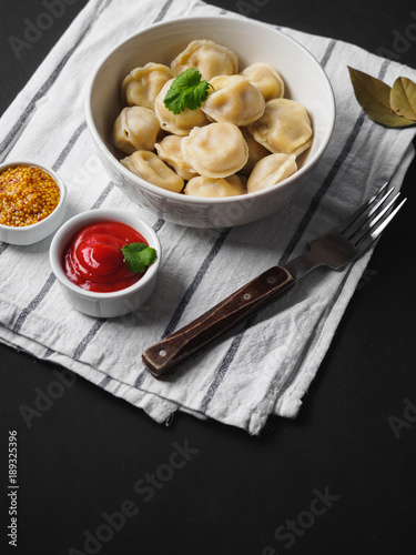 Dumplings on plate at wooden desk on black background