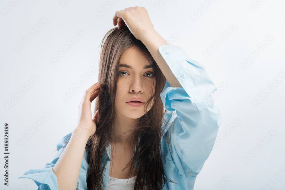 Naklejka premium Exhausted life. Reflective beautiful good looking woman staring straight and touching hair while lost in dreams 