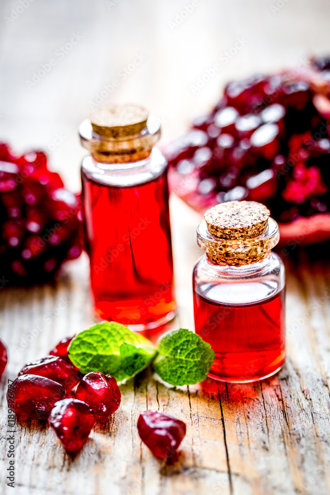 sliced pomegranate and extract in glass on wooden background sliced pomegranate and extract in glass on wooden background