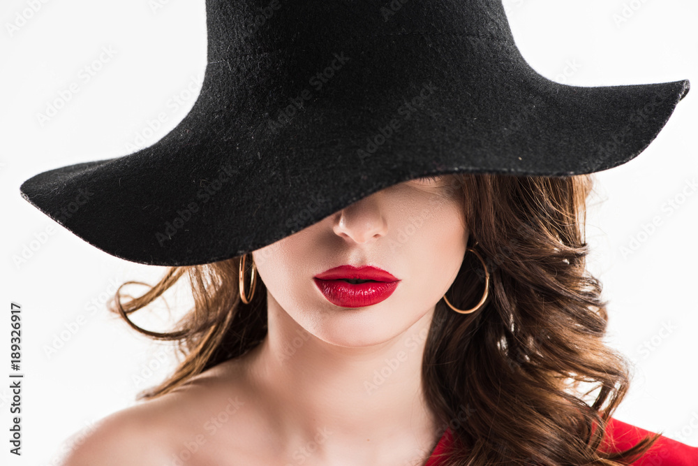 attractive woman hiding eyes under black hat isolated on white attractive woman hiding eyes under black hat isolated on white