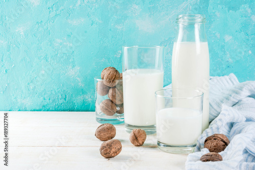Vegan alternative food, walnut non-dairy milk on light blue background, copy space