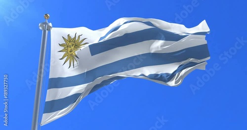 Flag of Uruguay waving at wind in slow with blue sky, loop photo