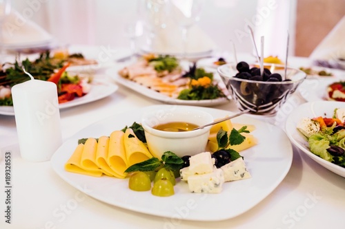 Photo of cheese platter and salad on the table