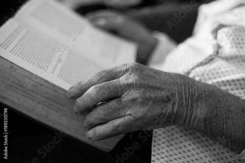 Old man reading book. Close up of wrinkled hands