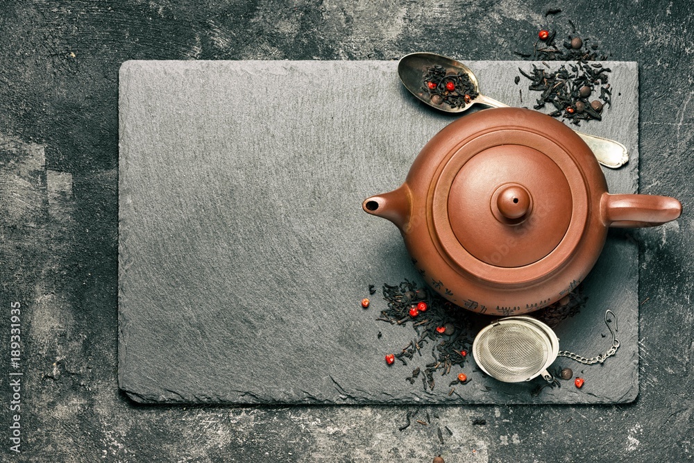 Chinese traditional red clay teapot with a black tea brewing on the  background of a black
