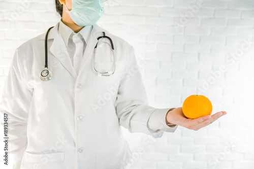 Bild auf Leinwand A doctor is showing orange in lab,Eatting Natural VitaminC nutrition is better t