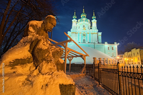 The monument to Taras Shevchenko in the snow and St. Andrew's Church on a hill at night. Andriyivskyy Descen (uzviz). Kyiv, Ukraine photo