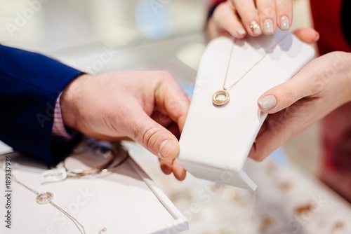 Man buying necklace in jewelry store.