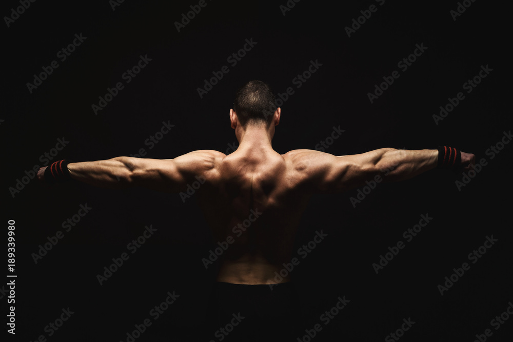Unrecognizable man shows strong back muscles closeup Unrecognizable man shows strong back muscles closeup