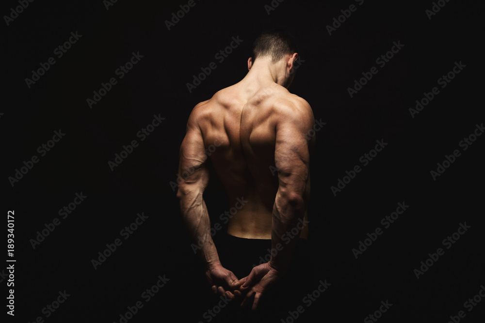 Unrecognizable man shows strong back muscles closeup - obrazy, fototapety, plakaty 