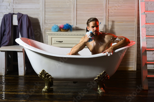 Man with beard and thoughtful face taking bath