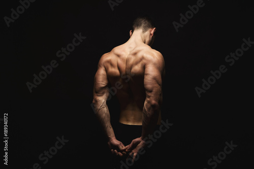 Unrecognizable man shows strong back muscles closeup