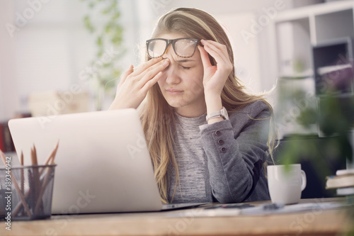 Young tired working woman at work photo