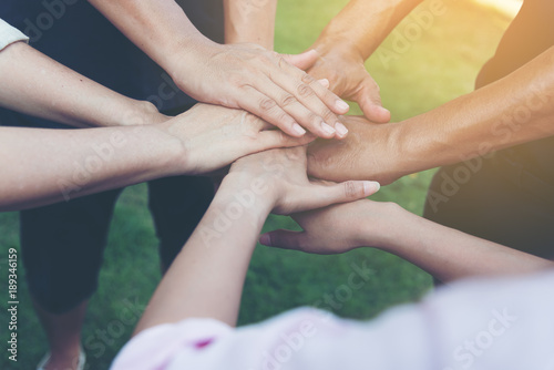 Closeup of stack of hands. Colleague putting their hands on top of each other symbolizing unity and teamwork while doing activity outdoor. People joining hand together as a business goal achievement.