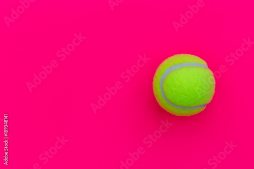 Yellow tennis ball isolated on pink background with copy space © Tom Eversley
