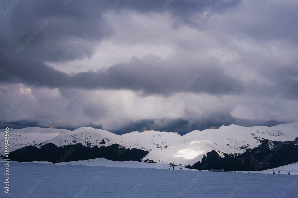Beautiful view of the winter ski resort. Mountains with clouds, in the distance ski lift.
Beautiful view of the winter ski resort. Mountains with clouds, in the distance ski lift.