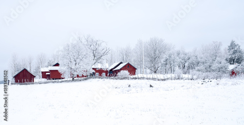 Farm barn in a cold winter landscape with snow and frost