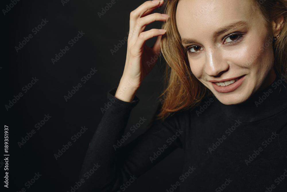 Obraz premium Stunning blonde girl. Long hair. Horizontal shot of astonished beautiful female model wears black turtleneck sweater, looks with bugged eyes and widely opened mouth.