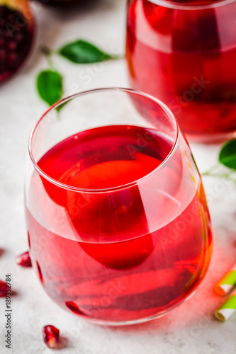 Glass of pomegranate juice on white marble background. Selective focus, copy space, close up.