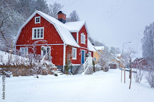 Winter scenery with red wooden house in Sweden photo