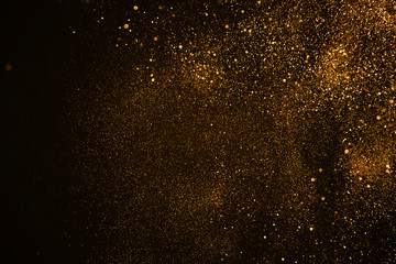 christmas gold sparkle glitter explosion dust particles background with bokeh, gold holiday happy new year and valentine day concept