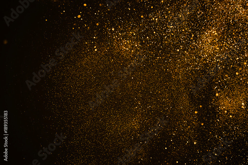 christmas gold sparkle glitter explosion dust particles background with bokeh, gold holiday happy new year and valentine day concept