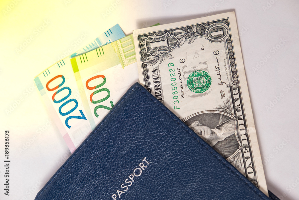 Obraz premium blue passport with dollar bills and Russian rubles, or euros on a white background