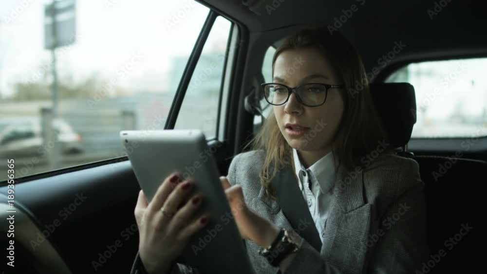 Young Businesswoman Using a Tablet Computer in the Car Young Businesswoman Using a Tablet Computer in the Car