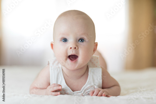 Cute baby wearing lying on tummy in nursery room photo