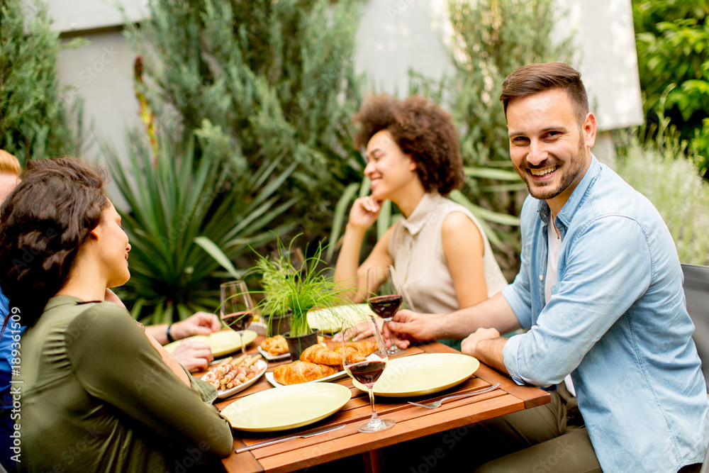 Fototapeta premium Friends grilling food and enjoying barbecue party outdoors