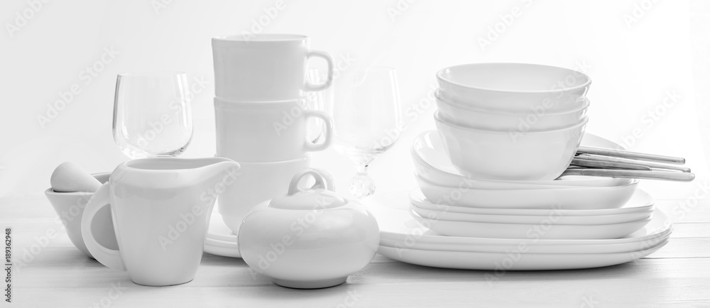 Set of plates and cutleries on light background Set of plates and cutleries on light background