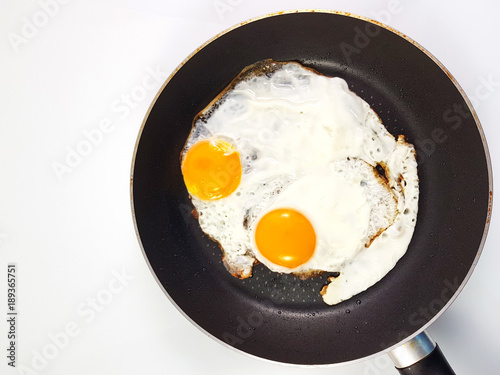 Delicious fried eggs in a pan with crispy concept background.