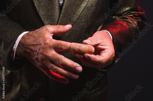 Magician shows trick with a fake finger. Manipulation with props. Sleight of hand.