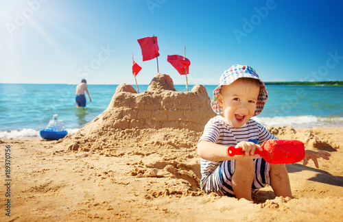 boy sitting smiling at the beach