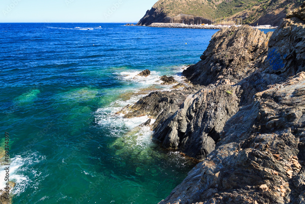 Rocky coast near tourist town Portbou (Costa Brava, Catalonia, Spain)