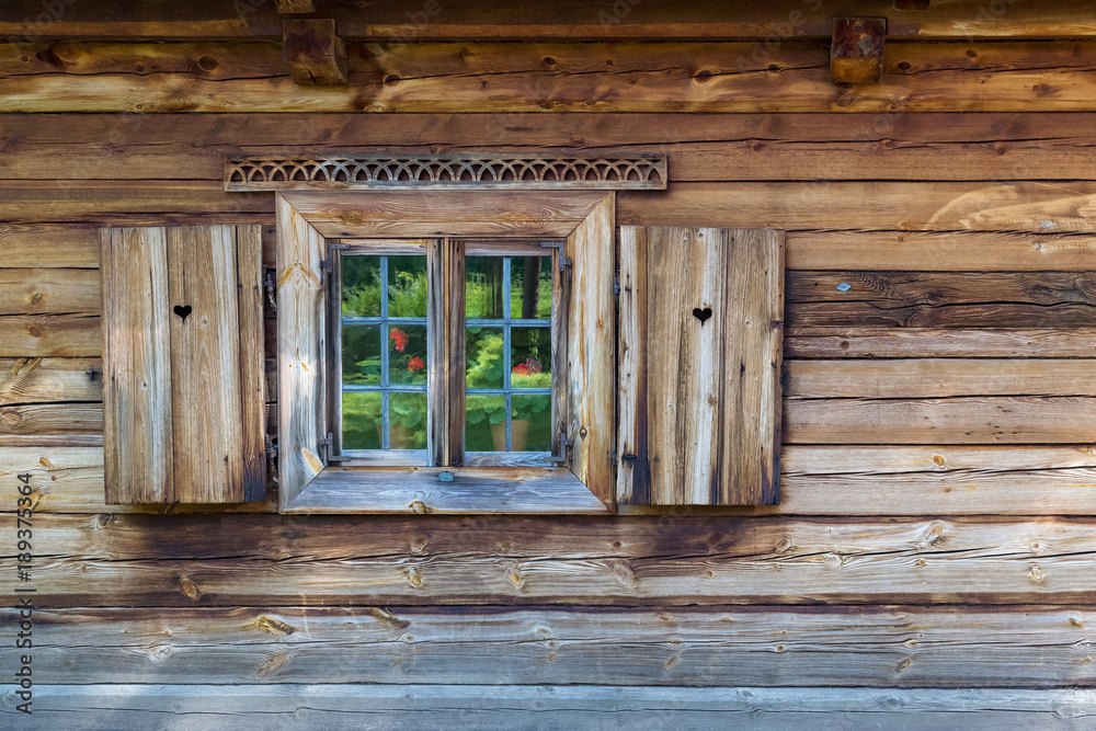 The old window of old wooden house. Background of wooden walls