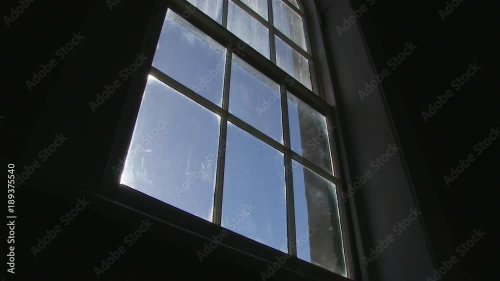 A medium shot of a window and sunlight. Camera slides to right