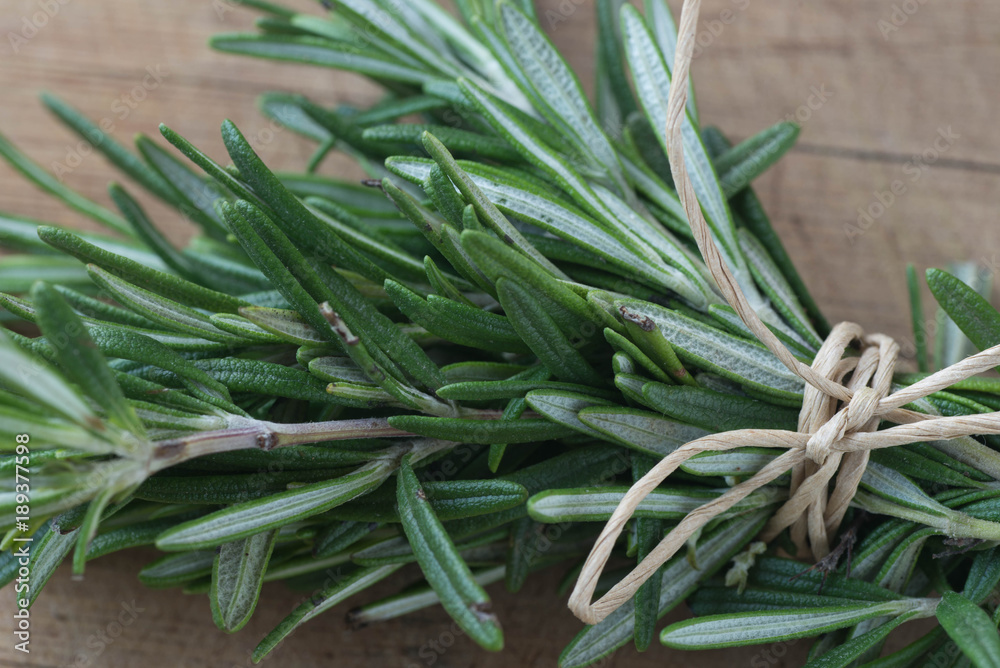 fresh rosemary twigs on wooden background fresh rosemary twigs on wooden background