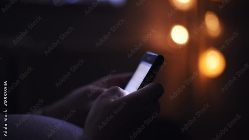 Pregnant woman using mobile phone in dark room, typing sms text message on smartphone, technology lifestyle and communication concept, shallow depth of field (dof)