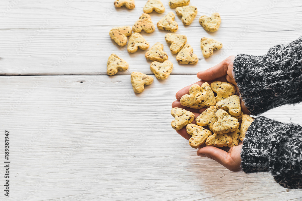 Fototapeta premium Homemade cookies with turmeric and flax seeds in the form of heart on white boards.
